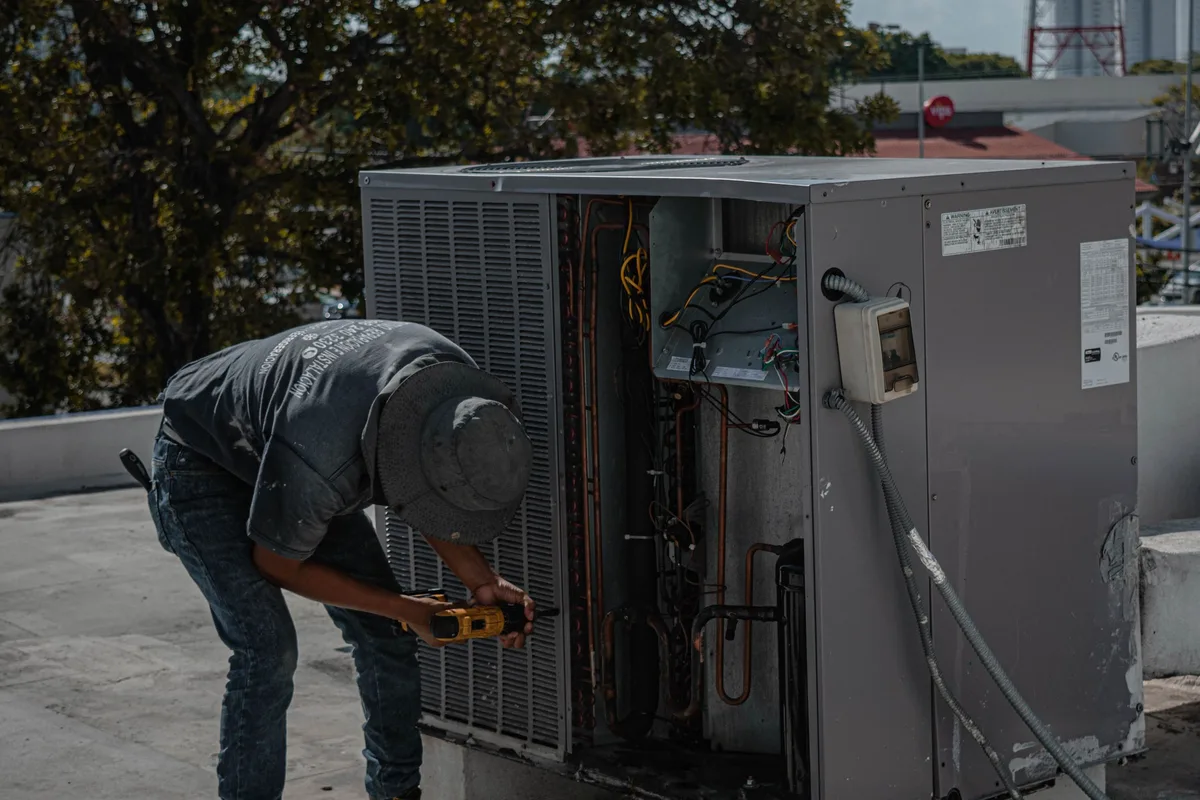 HVAC technician servicing an open packaged air conditioning unit